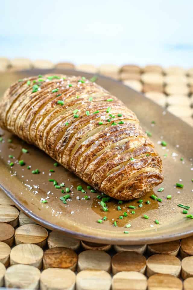 Golden baked potato rosette garnished with chopped chives and a sprinkle of salt.