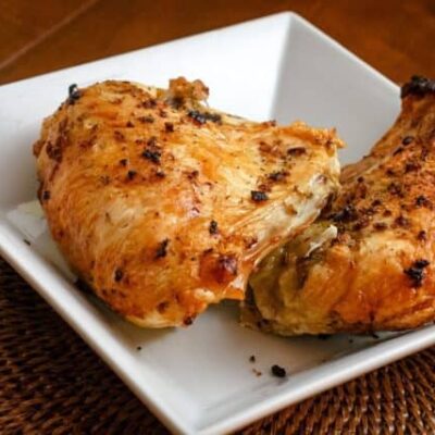 roasted herb and garlic split chicken breasts in a serving dish