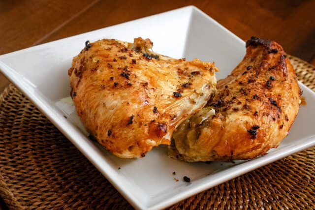 roasted herb and garlic split chicken breasts in a serving dish