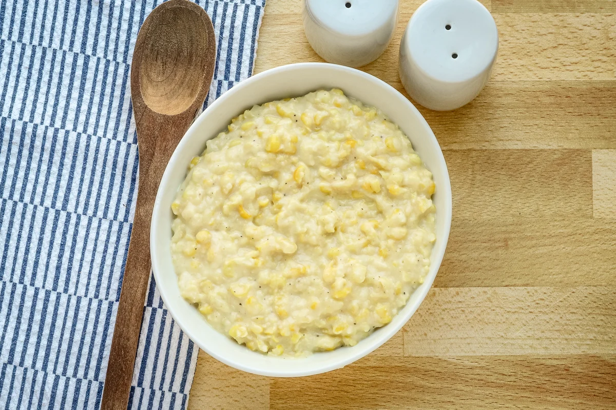 A serving dish of homemade cream style corn.