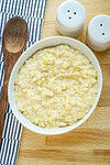 Creamy corn and potato casserole in a white bowl.