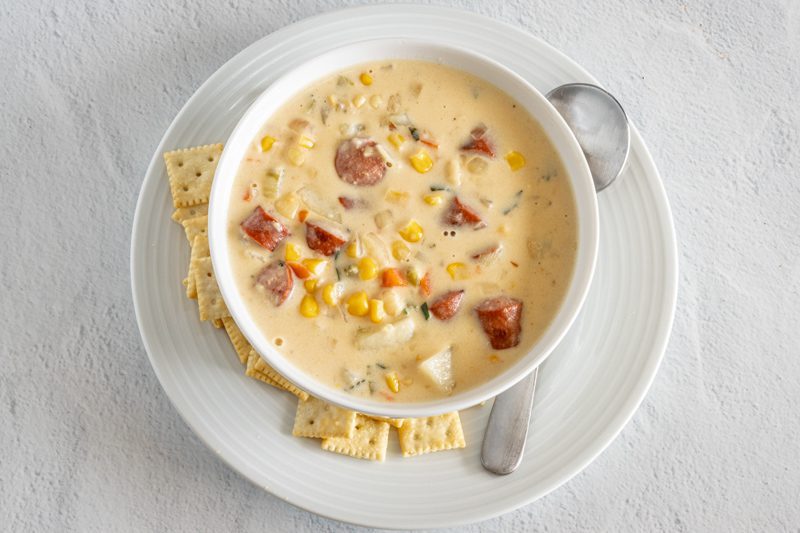 A bowl of hot dog chowder with corn and potatoes
