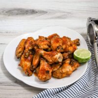 Hot honey chicken wings preparation with hot sauce, butter, honey, lime zest and juice, garlic powder, and onion powder.