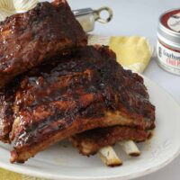 A platter of pressure cooked baby backed ribs slathered with BBQ sauce.