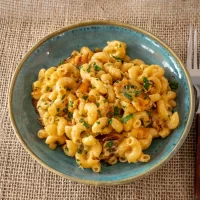 Creamy macaroni and cheese with shredded cheese and herbs.