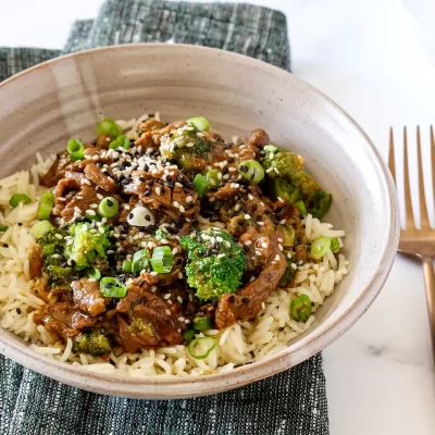Steamed rice topped with stir-fried broccoli, beef, and sesame seeds.