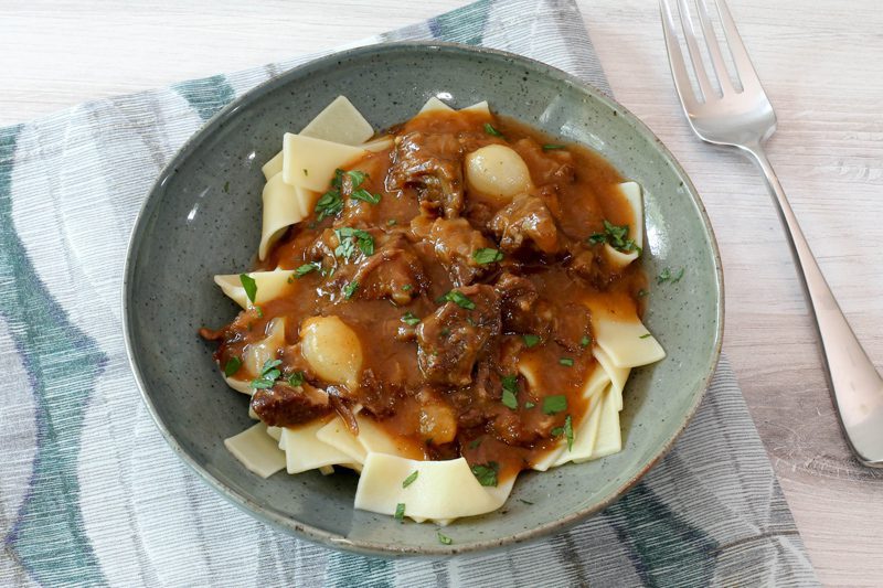 instant pot beef carbonnade, a beef and beer stew, served on pappardelle in a bowl