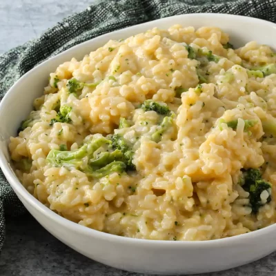 Creamy broccoli cheddar risotto in a white bowl.