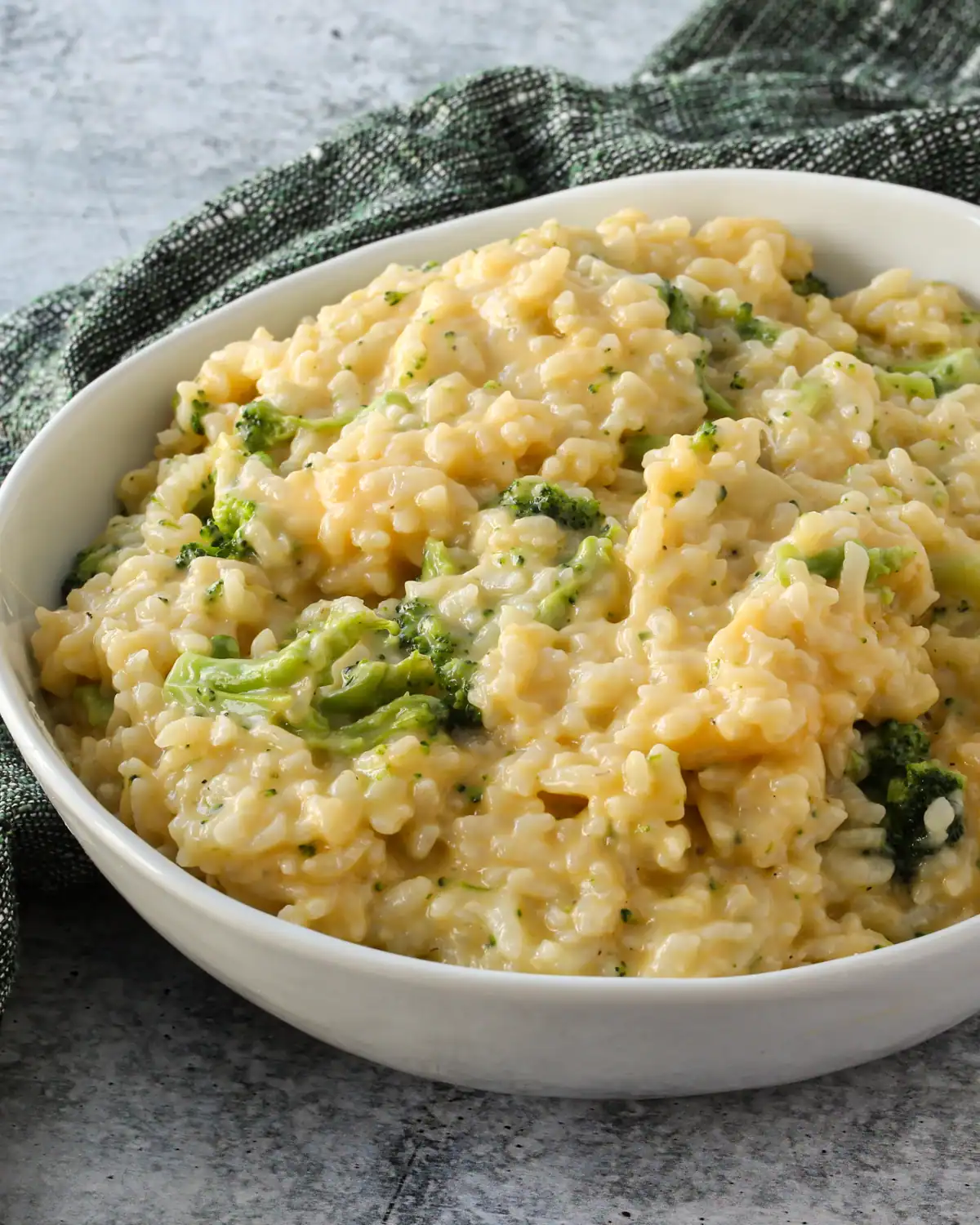Creamy broccoli cheddar risotto in a white bowl.