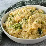 Creamy broccoli and cheese risotto in a white bowl.