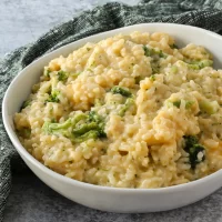 Creamy broccoli and cheese risotto in a white bowl.