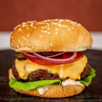 Instant Pot burger in a sesame seed bun with cheese and toppings.
