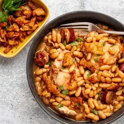 Baked chicken with white beans and sausage in a savory broth.