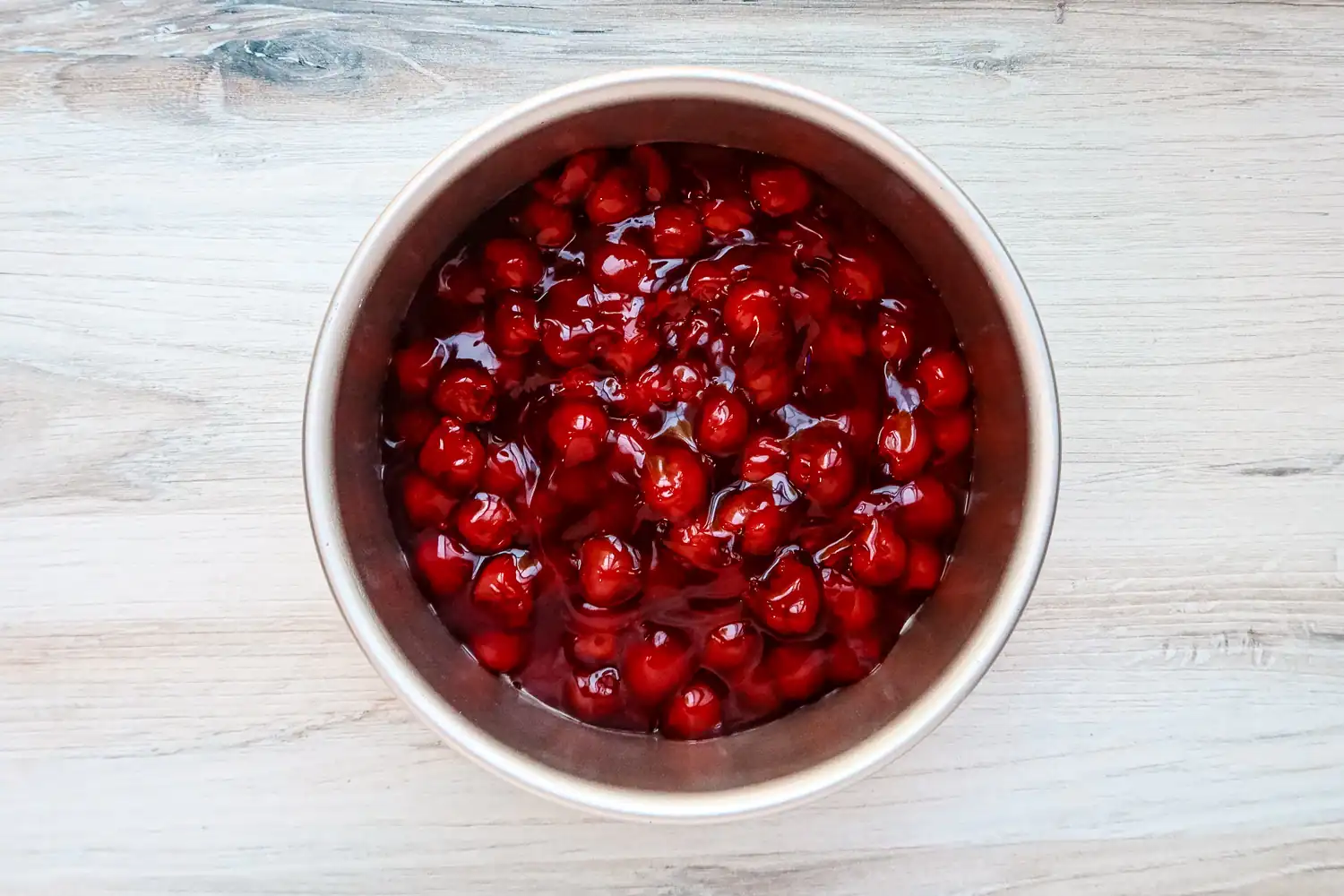 Instant Pot cherry upside-down cake preparation: cherries in the pan.