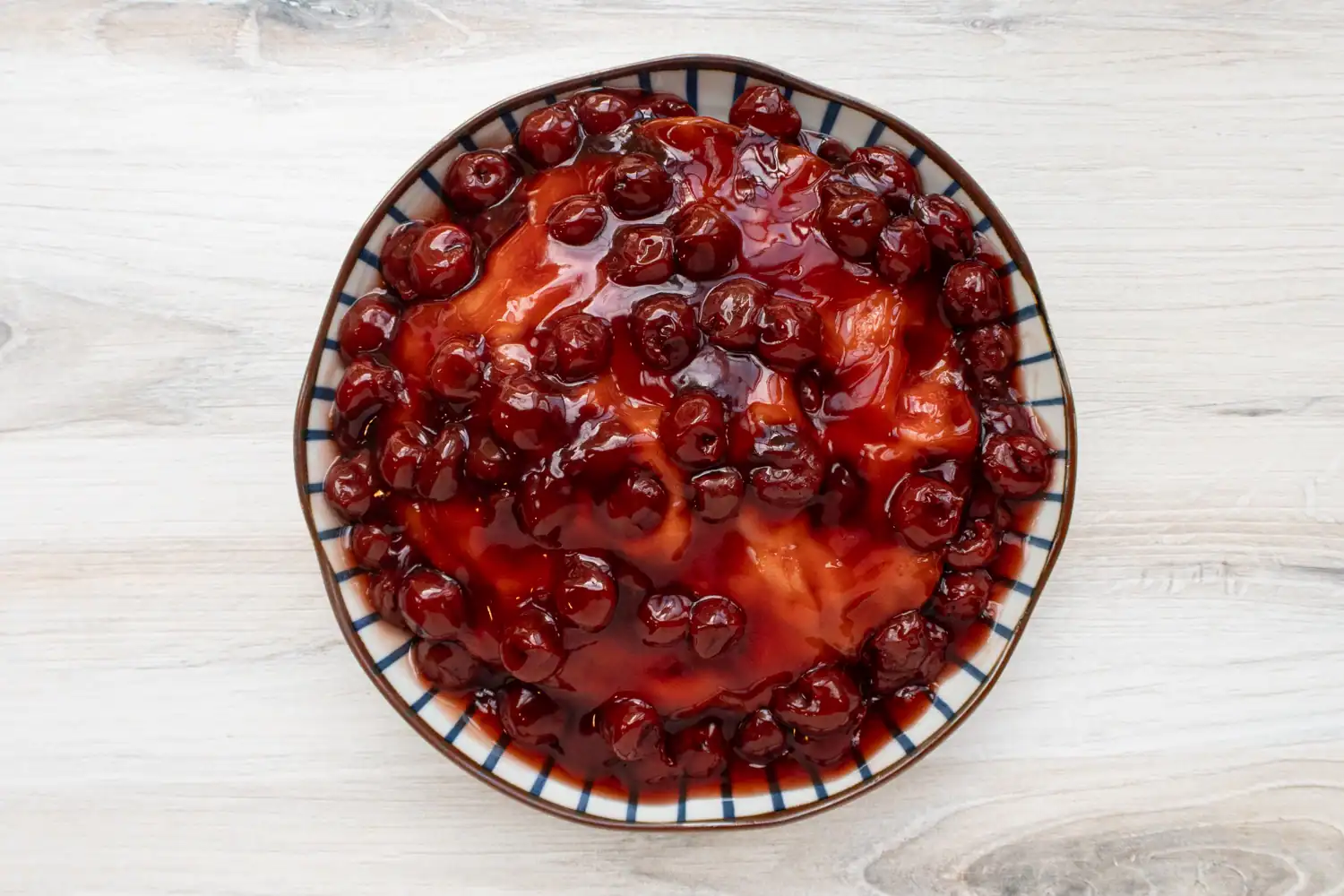 Instant Pot cherry upside-down cake preparation: the cake is inverted onto a plate.