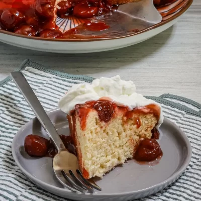 Sweet cherry cheesecake with whipped cream on top.