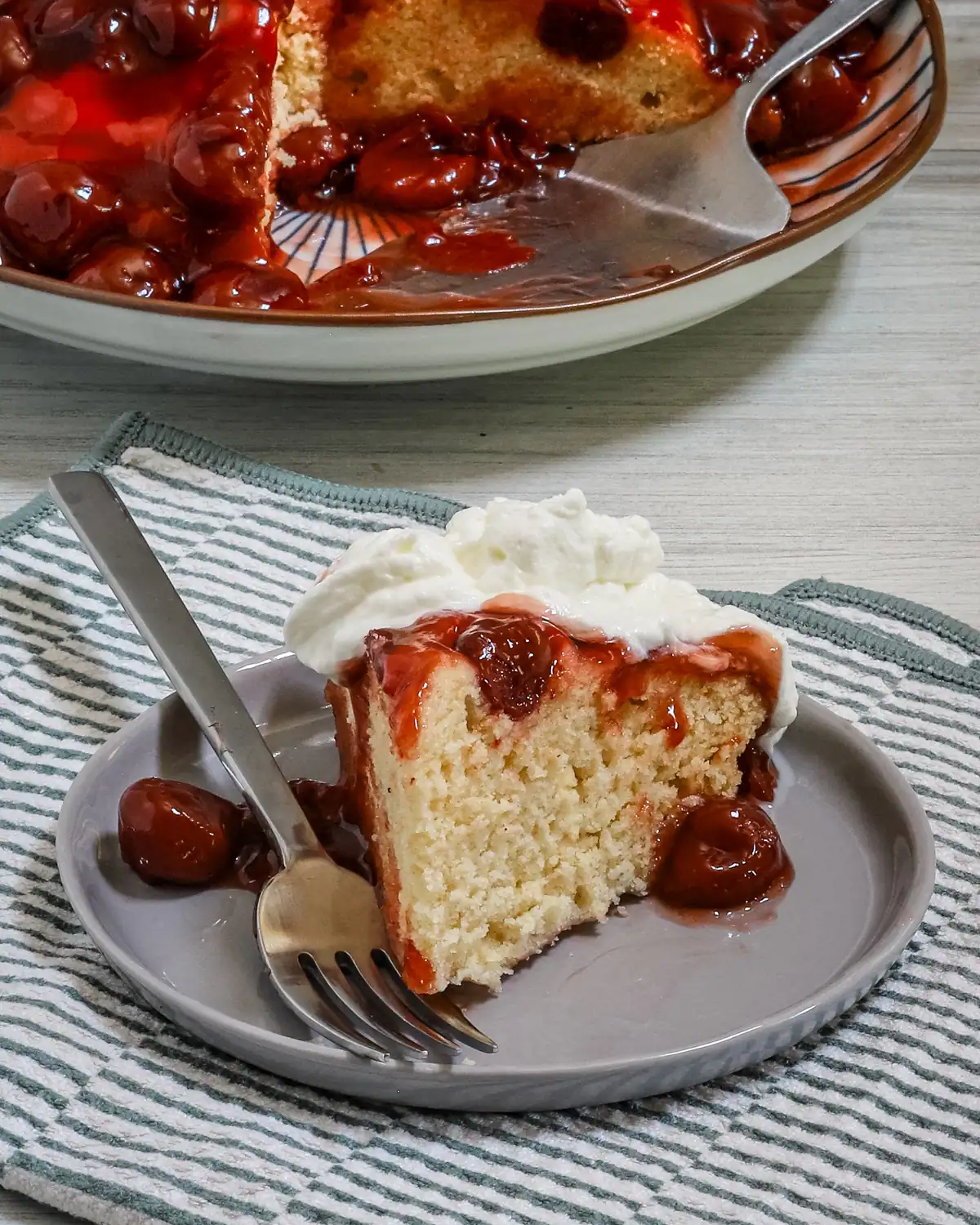 Sweet cherry cheesecake with whipped cream on top.