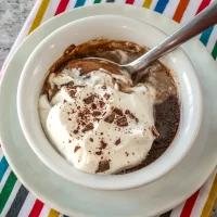 Rich chocolate pudding with whipped cream and chocolate shavings.