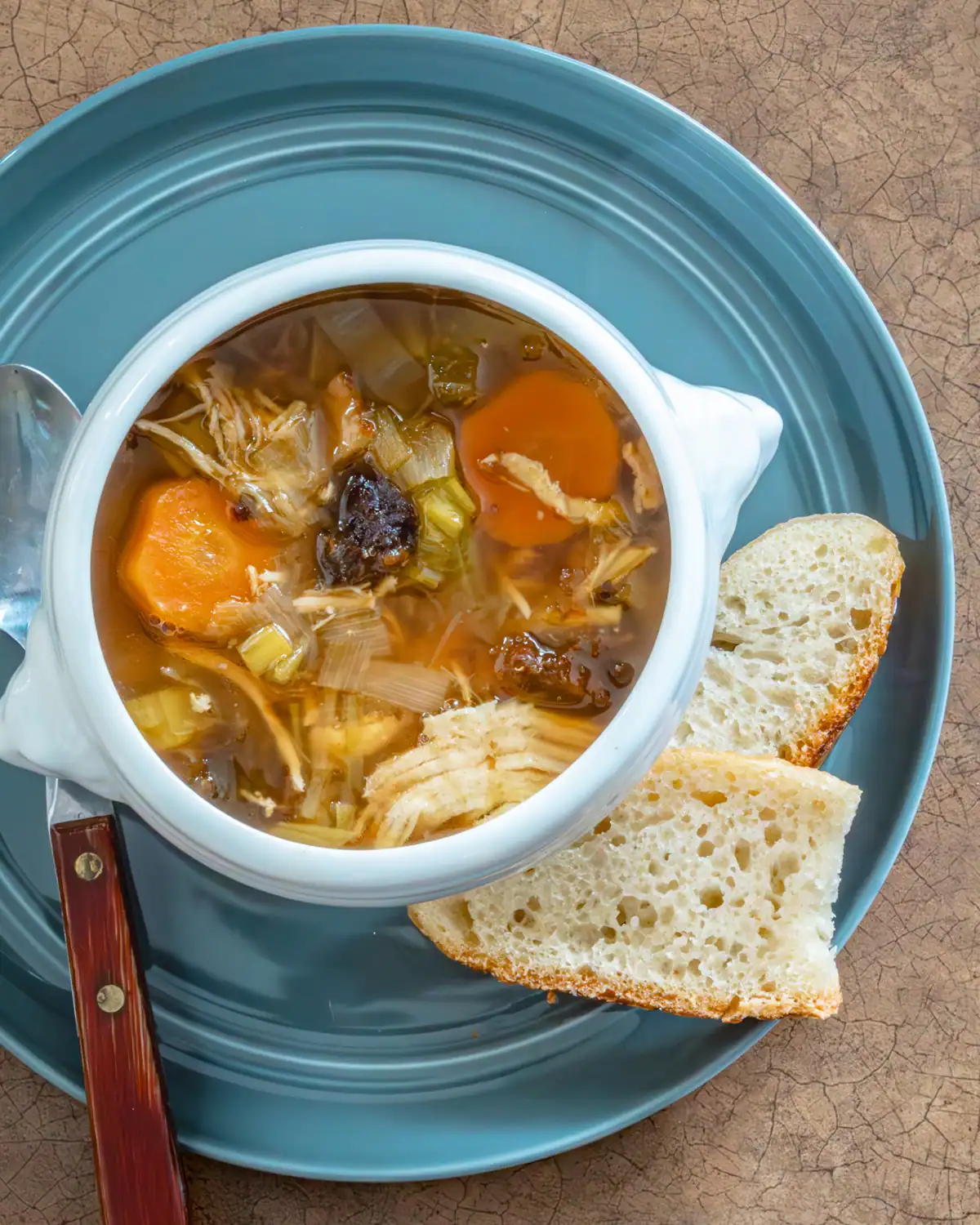 Warm vegetable soup with carrots and celery, served with slices of crusty bread.