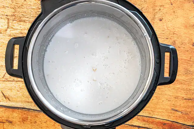 Instant Pot coconut rice prep: rice and liquids in the Instant Pot.