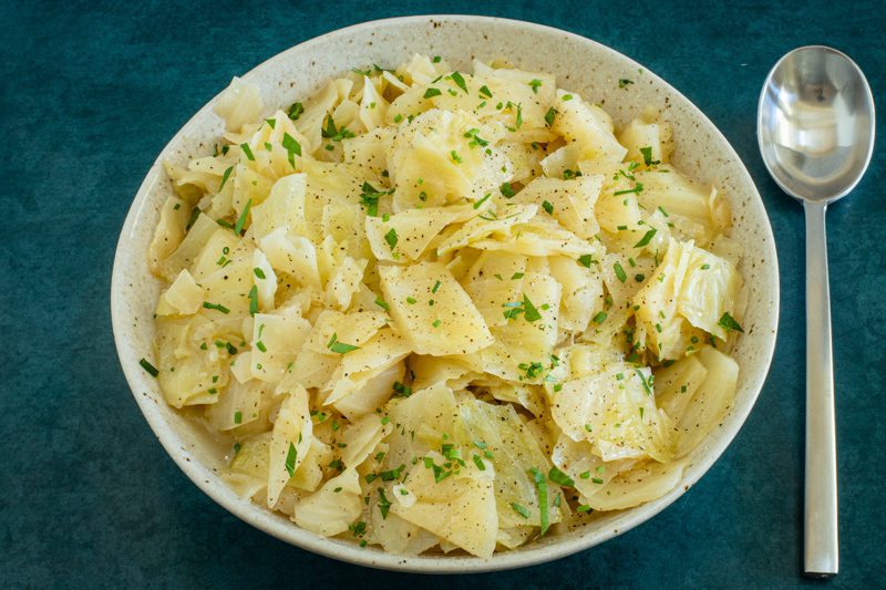 instant pot cooked cabbage in a serving bowl with parsley garnish