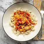 Steamed rice topped with hearty vegetable curry and tender chicken pieces.
