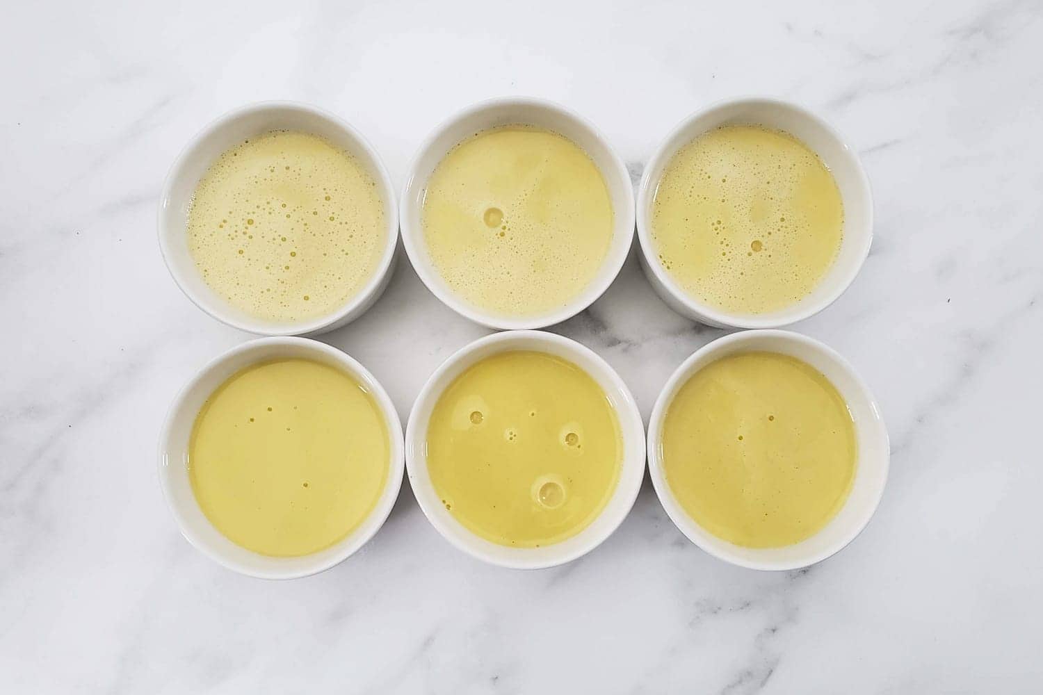 Ramekins filled with crème brûlée custard.