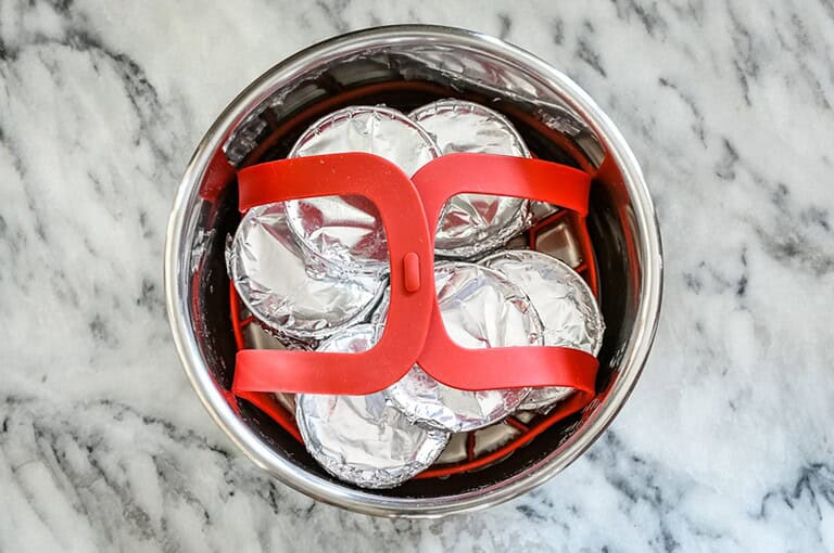 - Boiled eggs wrapped in aluminum foil inside a steamer basket.