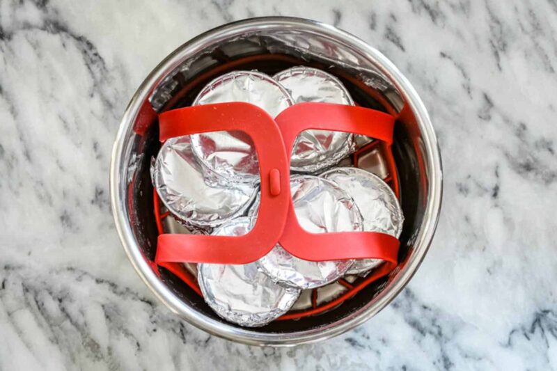- Boiled eggs wrapped in aluminum foil inside a steamer basket.