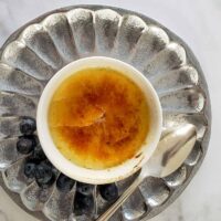 A serving of Instant Pot créme brulèe with blueberries.