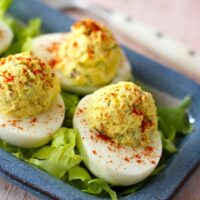 Instant Pot deviled eggs on a bed of lettuce and a sprinkle of paprika.