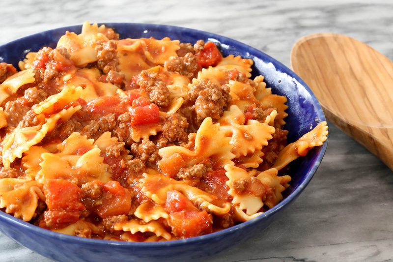 instant pot beefy farfalle and tomatoes in a blue bowl