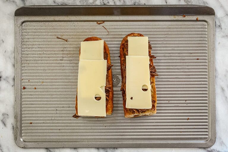 Toasted bread with melted cheese slices on top, ready for serving.