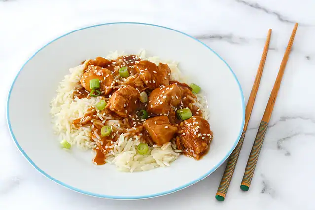 A plate with General Tso's chicken on rice, a Chinese take-out favorite.