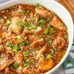 Creamy chicken and vegetable stir-fry with sesame seeds and chopped green onions.