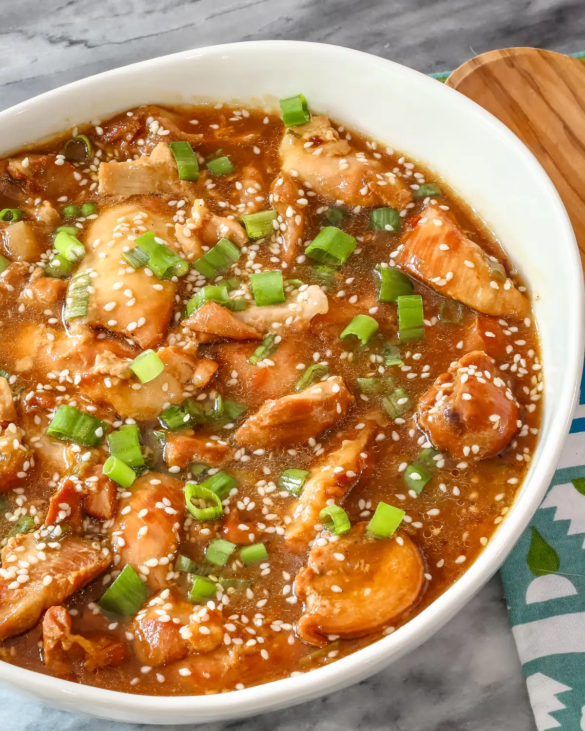 Creamy chicken and vegetable stir-fry with sesame seeds and chopped green onions.