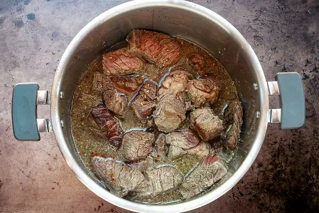 Instant Pot Italian beef prep: add the liquids and seasonings to the beef.