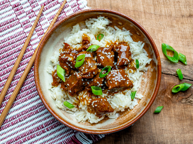 Korean beef on rice with garnishes.