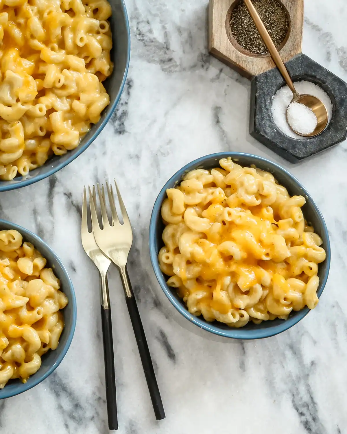 Golden baked macaroni and cheese in blue bowls.