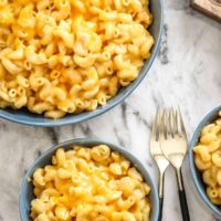 Instant Pot macaroni and cheese in bowls with forks on the side.