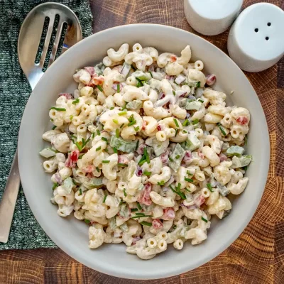 Creamy pasta salad with chopped vegetables and herbs.