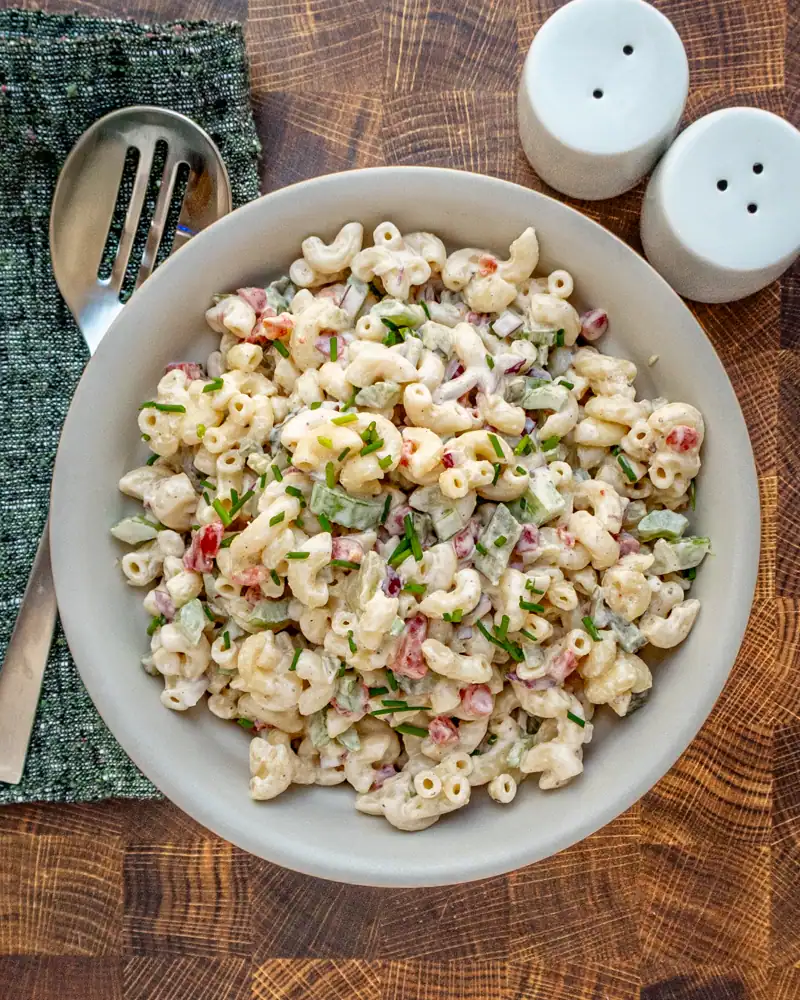 Creamy pasta salad with chopped vegetables and herbs.