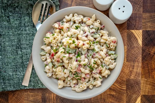 Instant Pot macaroni salad in a serving bowl with chives for garnish.