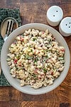 Creamy macaroni salad with chopped vegetables and fresh herbs.