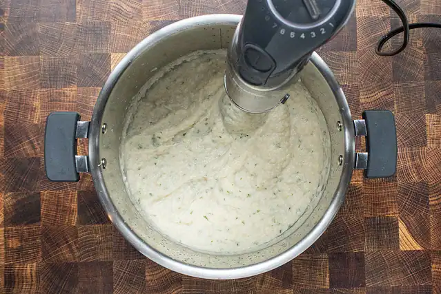 Processing the cauliflower with an immersion blender.