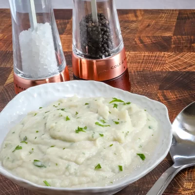 Creamy mashed potatoes garnished with chopped herbs.