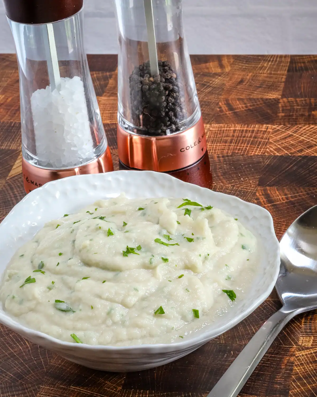 Creamy mashed potatoes garnished with chopped herbs.