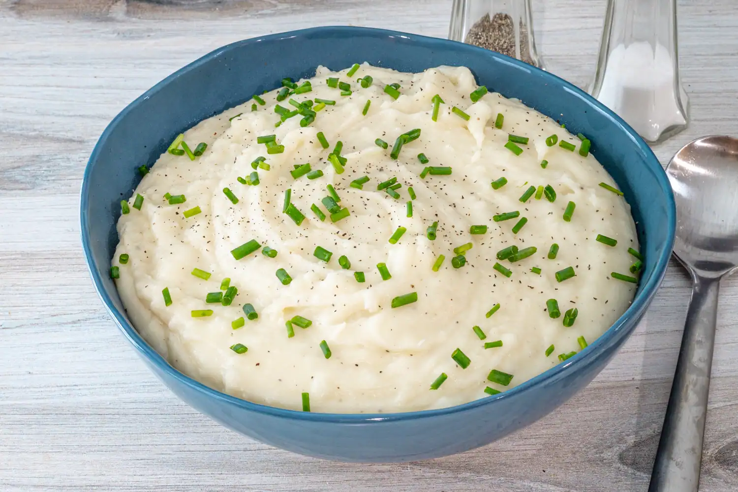 A bowl of Instant Pot pressure cooker mashed potatoes with garnish of herbs.