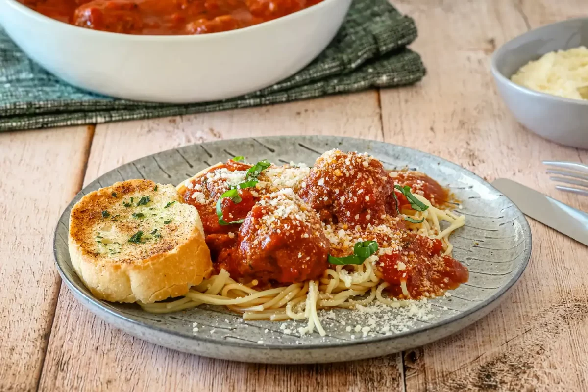 A plate of Instant Pot meatballs and sauce shown on spaghetti.