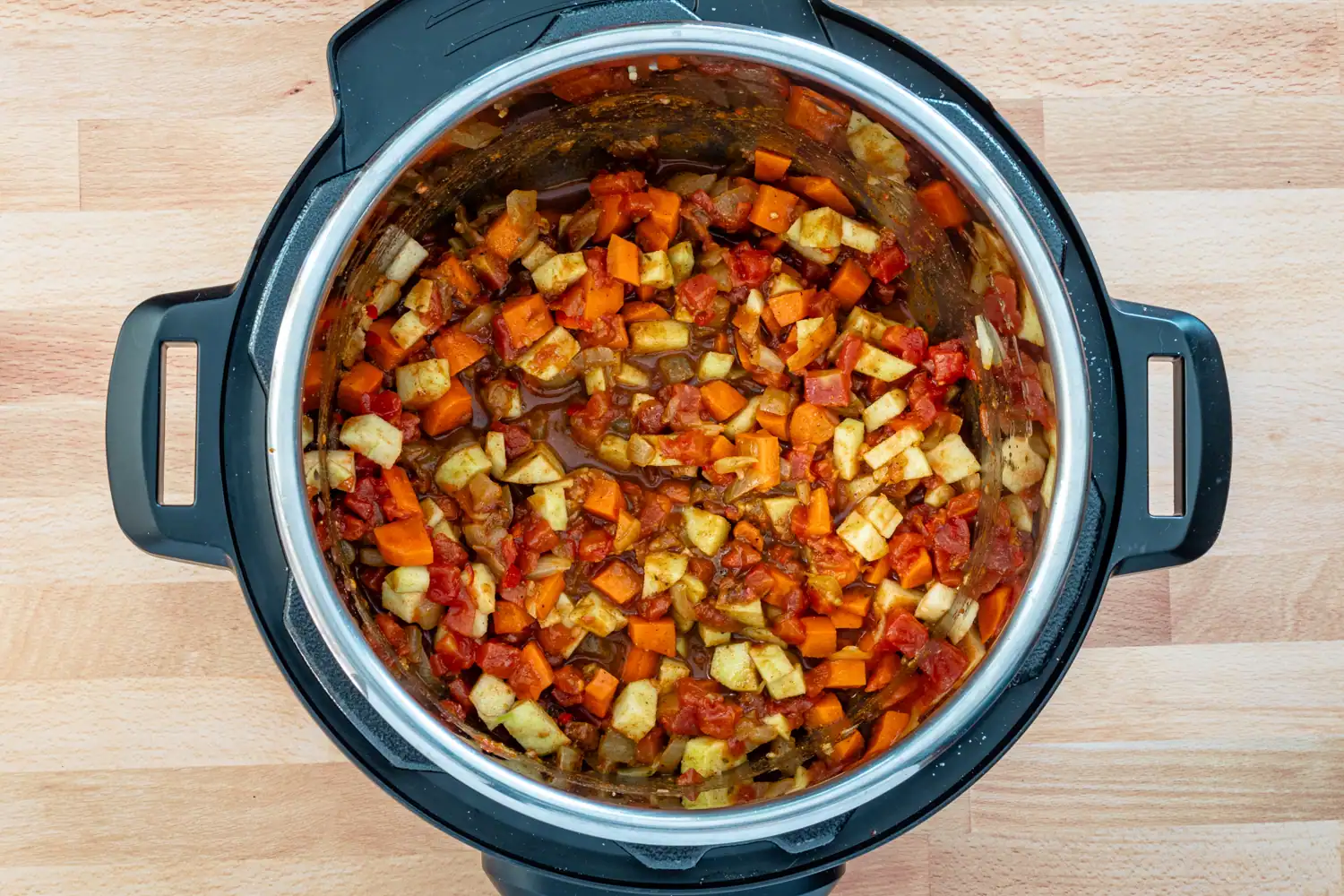 Vegetables, tomatoes, and apple added to the Instant Pot with chicken stock.